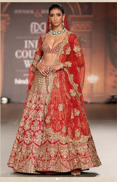 Lehenga is embellished with zardozi, sequins, and glass pipes