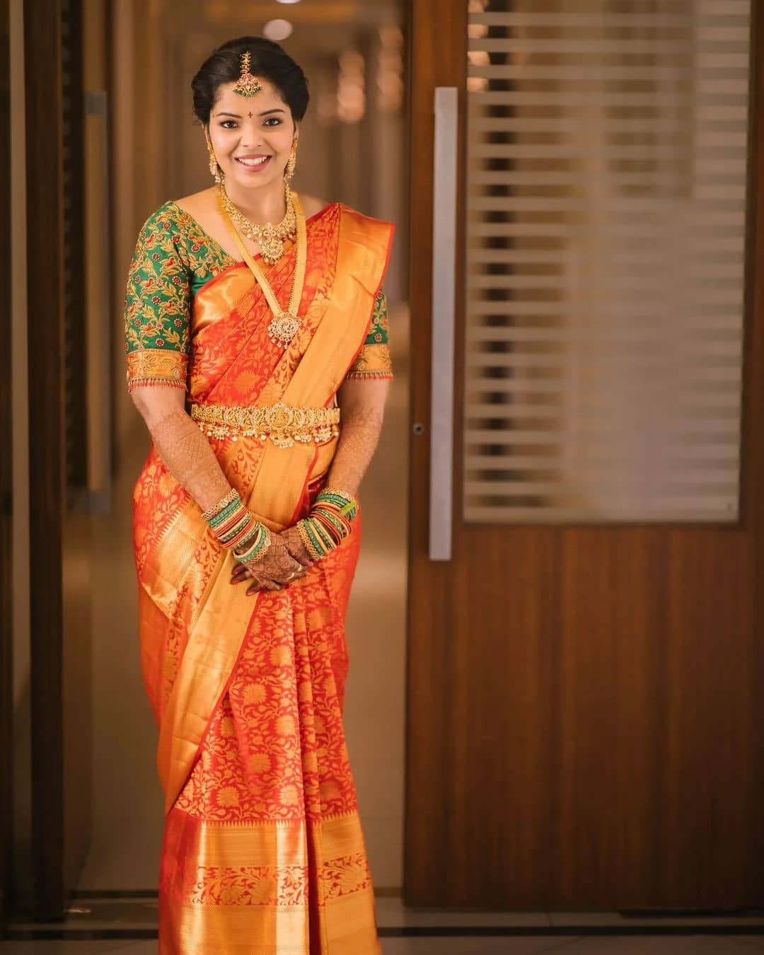 Orange saree paired with parrot green blouse with puff hands and Maggam  work along with waist belt | Orange saree, Saree, Blouse