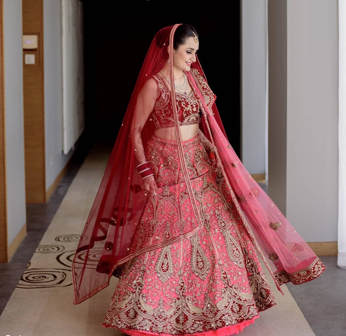 Coral pink Punjabi bridal lehenga with cut sleeves <em>choli</em> and net <em>dupatta</em>