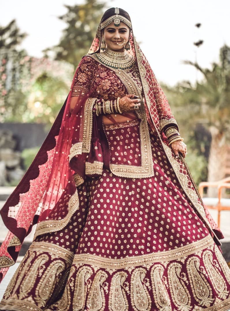 Maroon Punjabi bridal lehenga with floral patterns on <em>choli</em>