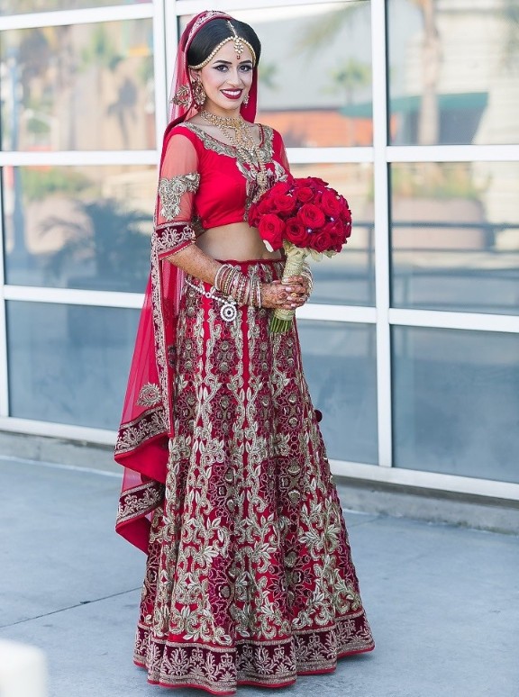 Cherry red bridal lehenga with minimal <em>choli</em> and floral patterns on lehenga
