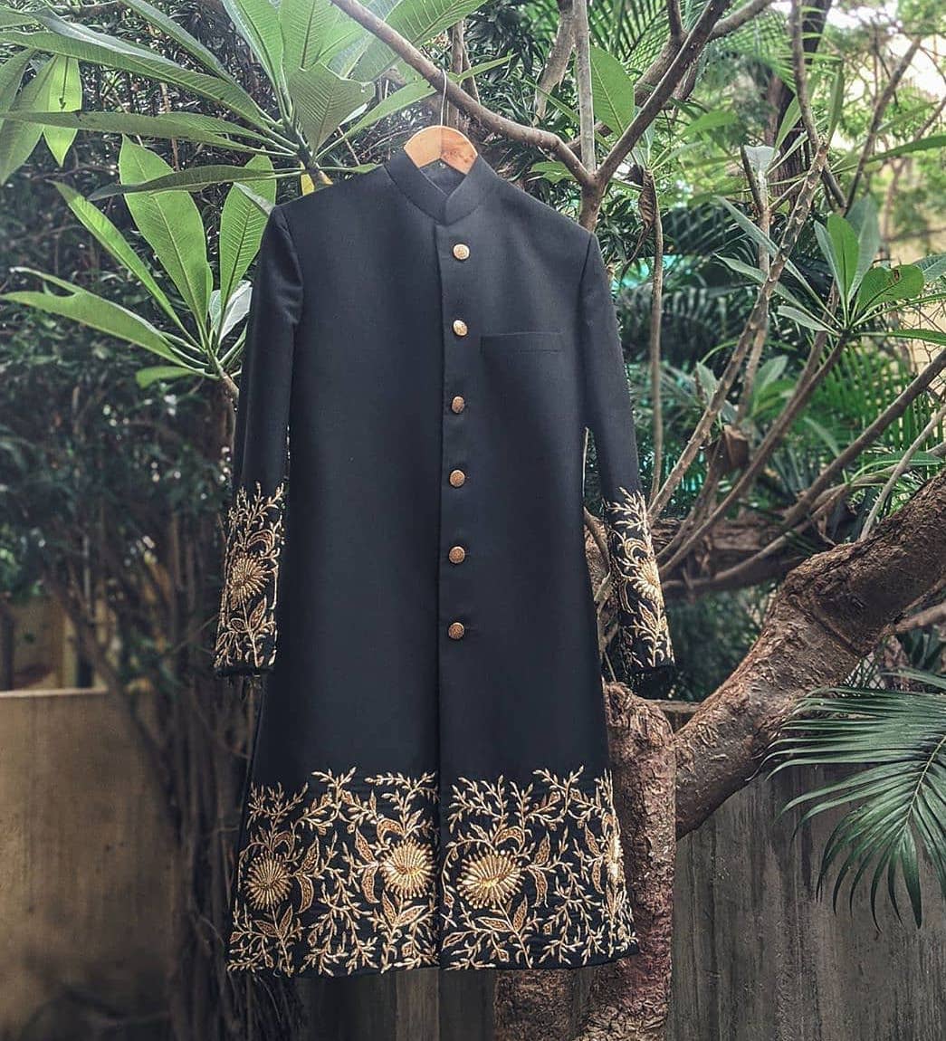 Black sherwani with golden embroidery work on sleeves and lower hem